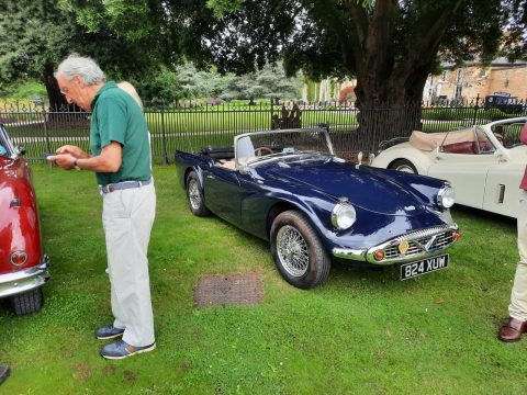 1960s Daimler SP250 Dart convertible in blue parked on grass.