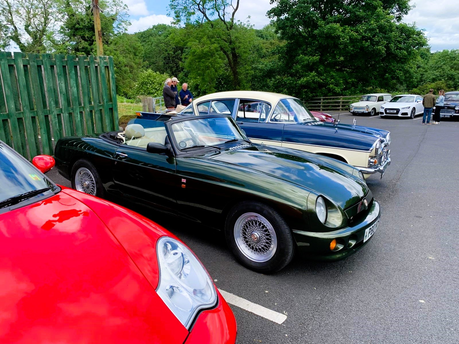 A dark green MG F convertible parked in a classic car show.