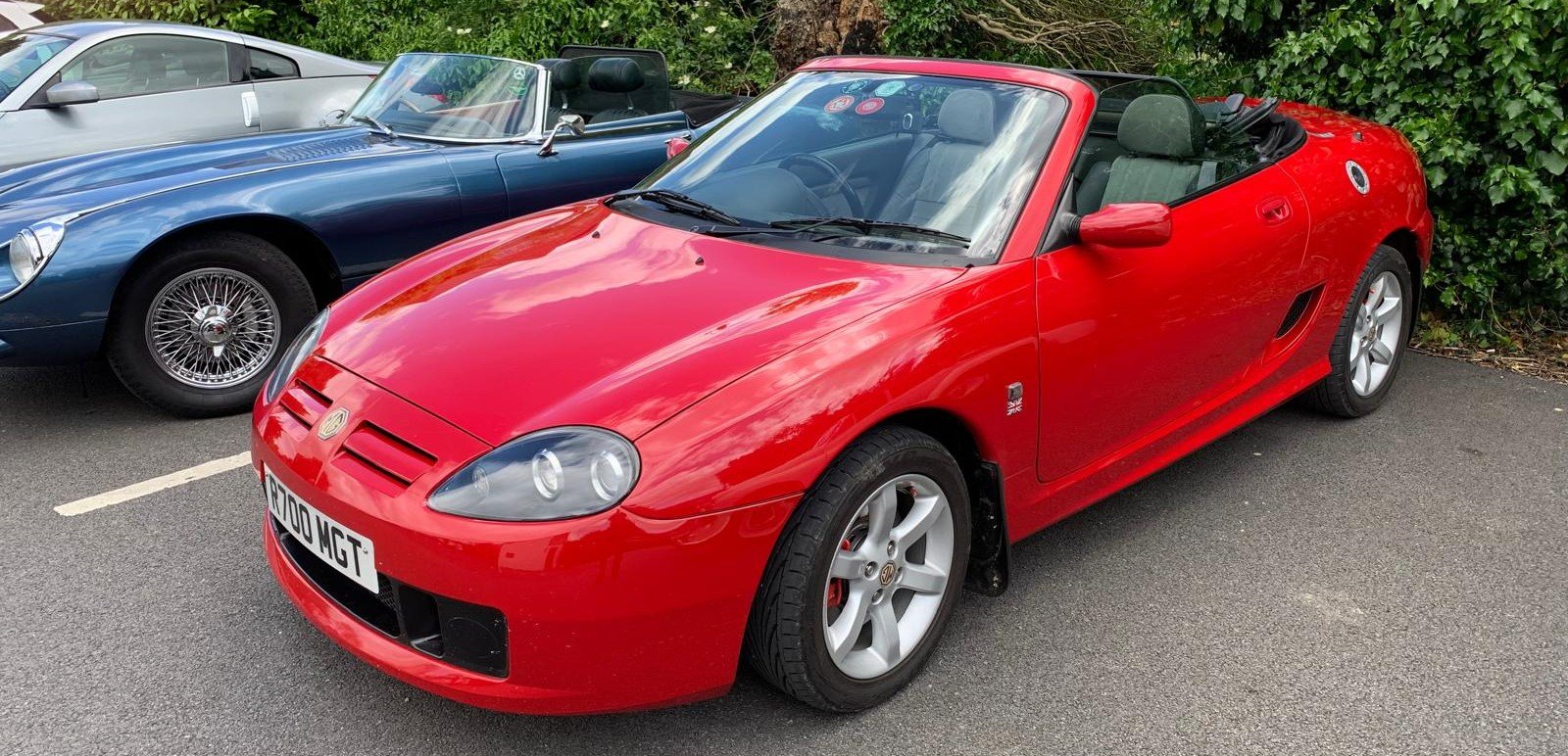 MG MGF in red parked next to other classic cars.