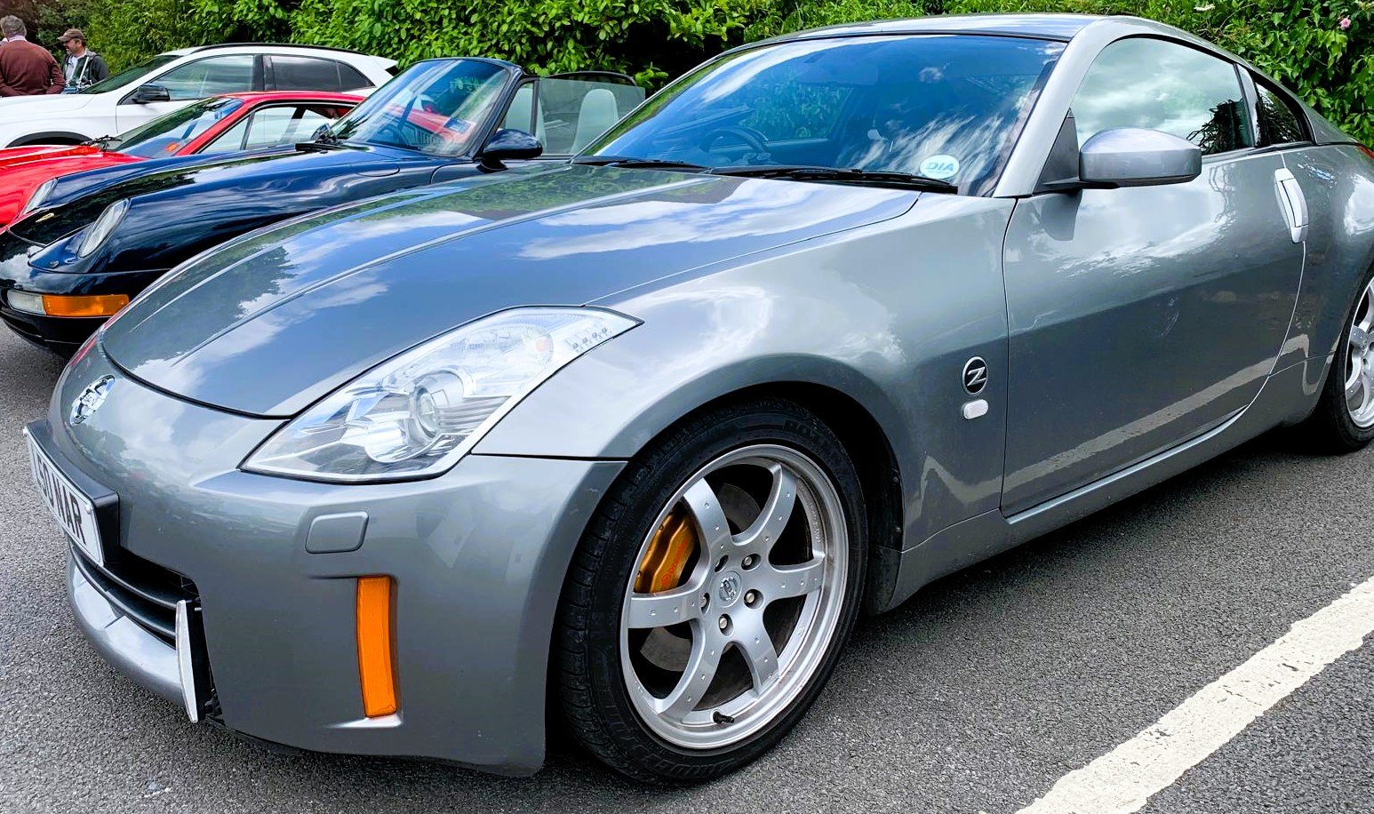 Side view of a Nissan 370Z Nismo in metallic grey parked in a car show